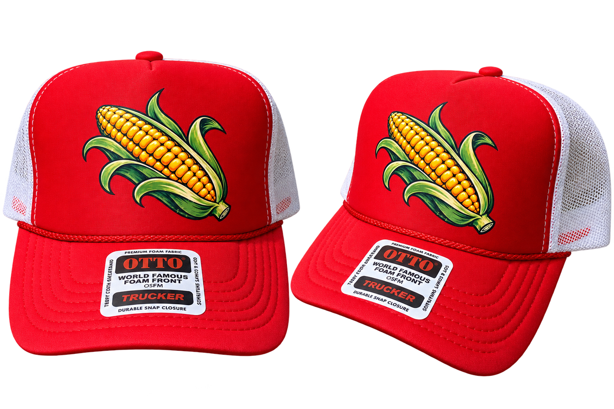 Two red trucker hats with white mesh back panels, featuring a large embroidered corn graphic on the front and a white rectangular brim patch that reads 'OTTO WORLD FAMOUS FORGED TRUCKER'.